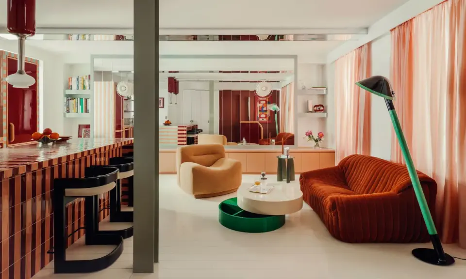 Un soggiorno con mobili colorati e un bancone da bar a righe. Stanza particolari in una casa che invita al relax e alla convivialità.