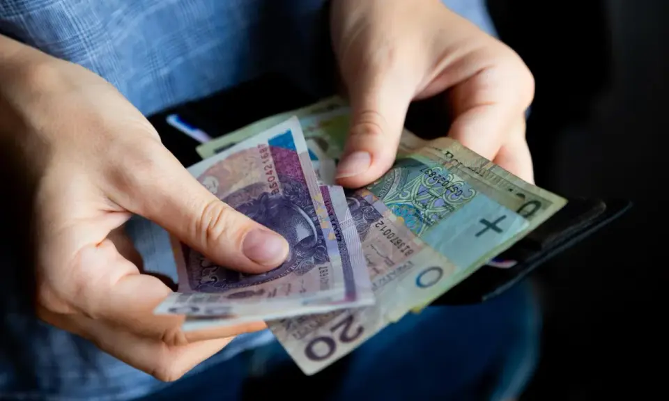 Ręce liczą banknoty, zastanawiając się, ile lat pracy do emerytury.