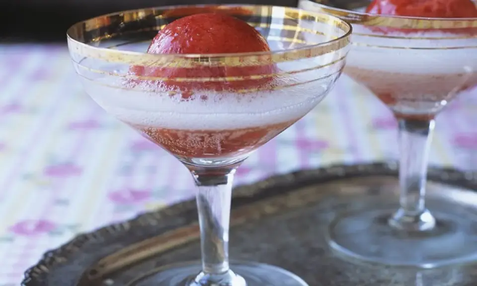 Zwei Gläser Champagner mit Erdbeeren, die auf einem Silbertablett stehen. Ein erfrischender Genuss.
