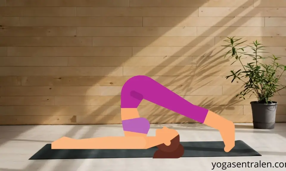 En person utför plogen yoga på en matta framför en trävägg.