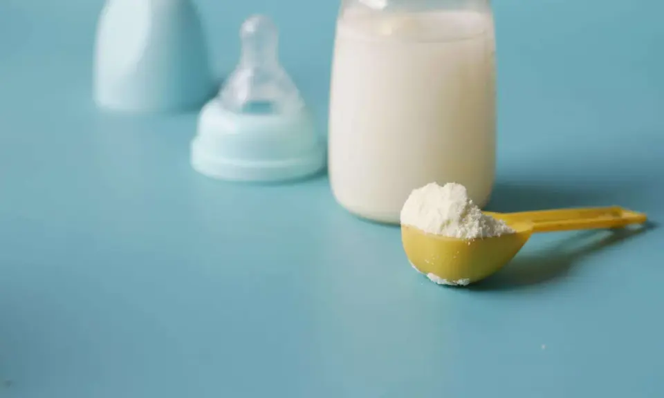 Biberon con latte, tettarella e misurino di latte in polvere, per capire quanto deve mangiare un neonato di 3 mesi.
