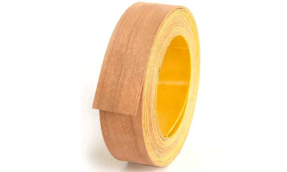Rollo de cinta de cantear de madera con reverso amarillo, listo para embellecer muebles.