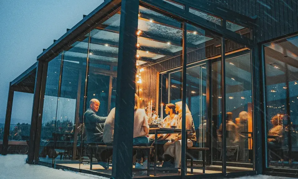 Gemütliches Abendessen im Glasanbau. Die Frage "was kostet ein Wintergarten" stellt sich hier angesichts der Atmosphäre nicht.