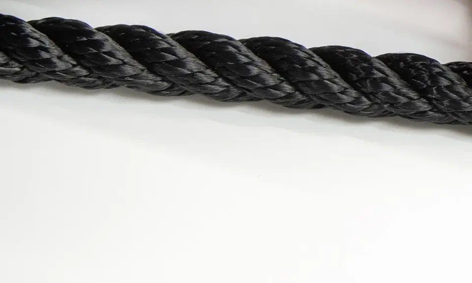Gros cordage noir tressé, prêt à sécuriser un navire lors de sa prochaine traversée.