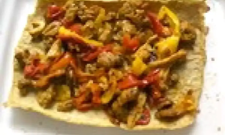 Un wrap poulet poivron, garni de morceaux de poulet et de poivrons colorés, prêt à être dégusté.