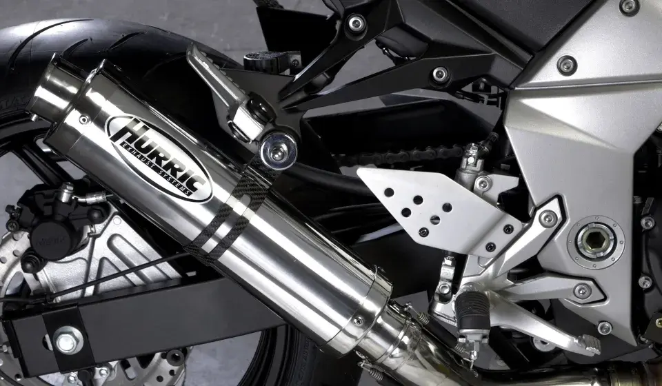 Błyszczący tłumik motocyklowy Hurric, element układu wydechowego, który może pomóc w uzyskaniu basowego brzmienia.