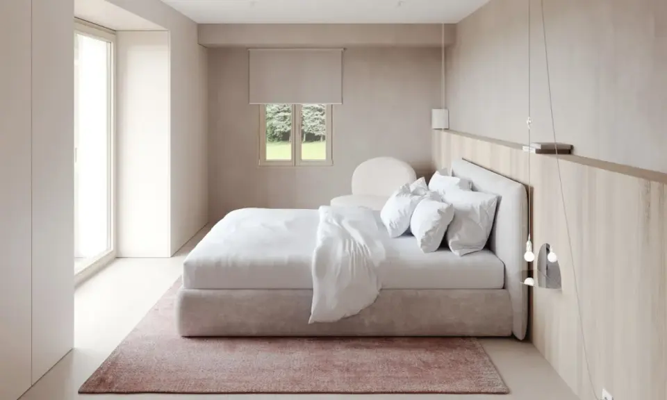 Chambre épurée avec lit blanc, tapis rose poudré et bois clair. Une belle inspi déco chambre pour un cocon de douceur.