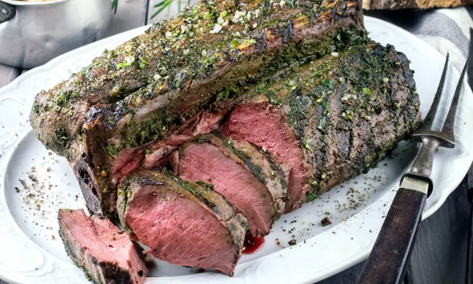 Saftige Hirschkeule, perfekt gebraten und mit Kräutern verfeinert, liegt auf einem Teller. Ein Festmahl für jeden Jäger.
