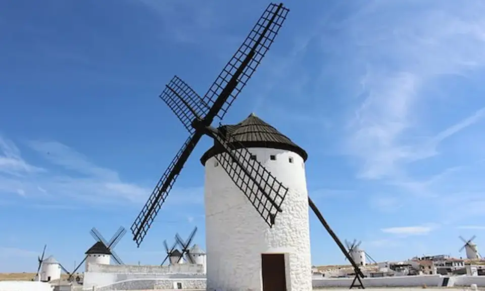 Molinos de viento blancos bajo un cielo azul. Un lugar que ver en Ciudad Real, como sacado de un cuento.