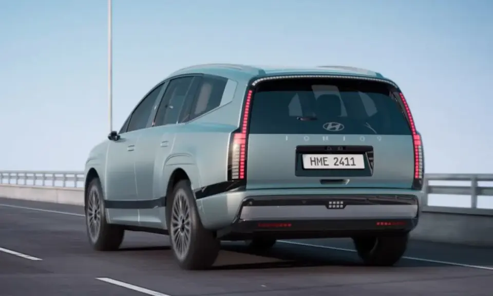 La nuova Ioniq 9, un SUV elettrico dal design futuristico, sfreccia su un'autostrada sotto un cielo azzurro.