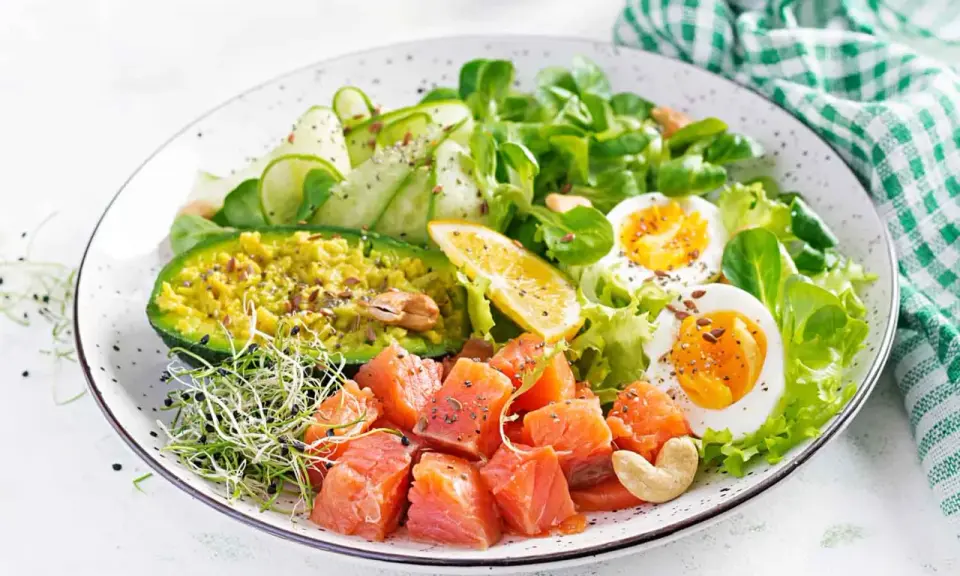 Kolorowa sałatka z łososiem, awokado, jajkiem i kiełkami – idealna na dietę niskowęglowodanową.
