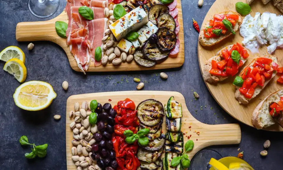 Ein köstlicher italienischer Abend mit Aufschnitt, Käse, gegrilltem Gemüse, Bruschetta und Pistazien. Perfekt für Genießer!