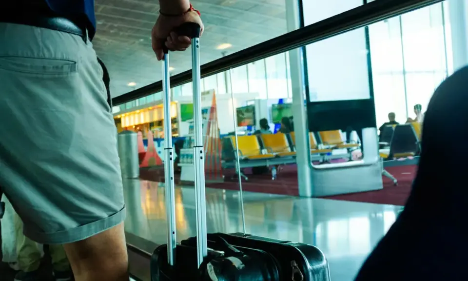 Osoba z walizką czeka na lot tunezyjskich linii lotniczych Nouvelair.