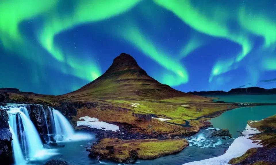 Islandia najpiękniejsze miejsca: góra Kirkjufell i wodospad pod tańczącą zorzą polarną.