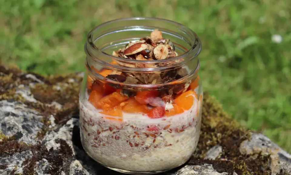 Veganes Overnight Oats im Glas mit Früchten und Nüssen, perfekt für einen gesunden Start in den Tag.