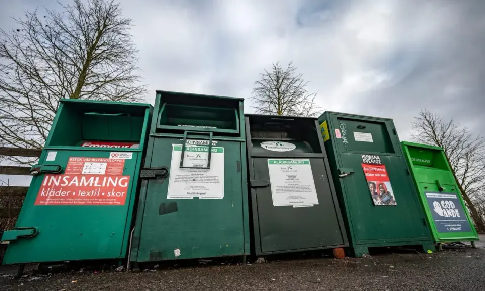 Gröna insamlingscontainrar för kläder, textil och skor. En del av dem visar vad som menas med återvinning genom att samla in begagnade kläder.