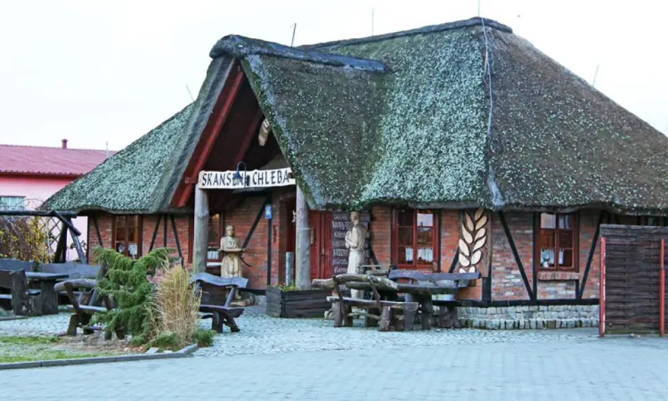 Skansen chleba z charakterystycznym, strzechą krytym dachem. Drewniane ławy i stoły zapraszają do odpoczynku.