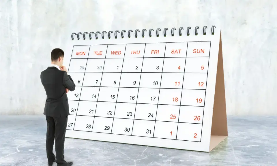 Hombre de traje frente a un calendario, pensando en el **artículo 9 de la LAU** y las fechas importantes.