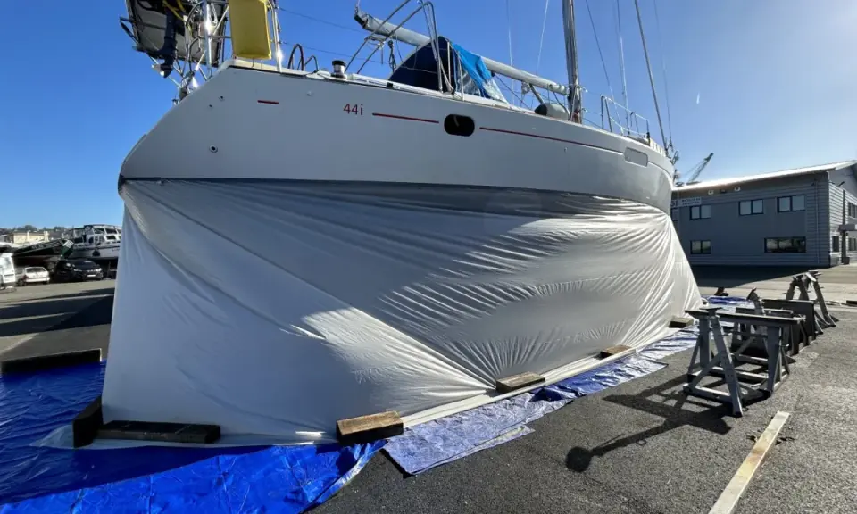 Bateau bâché, prêt pour le sablage de sa coque. Le prix du sablage coque bateau est une étape clé pour sa rénovation.