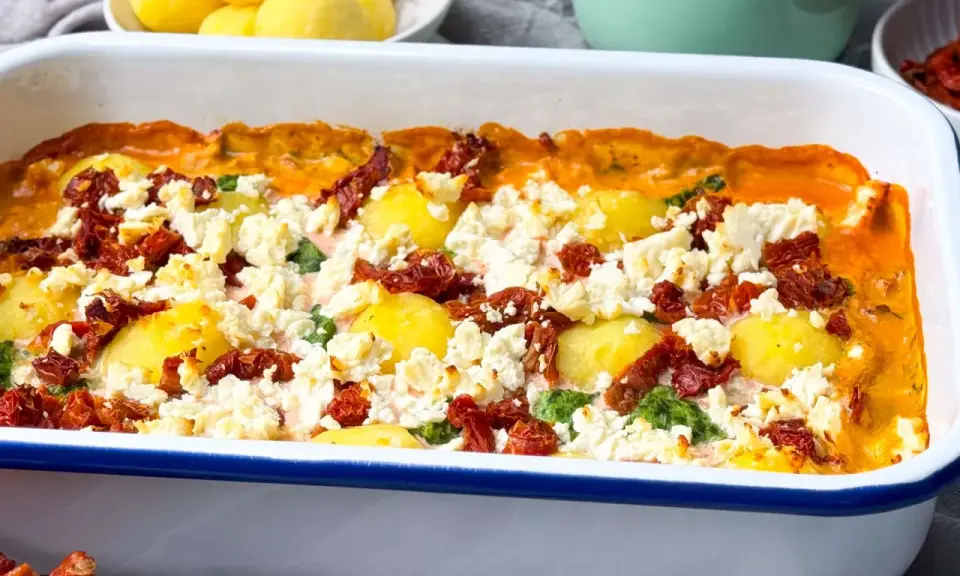 Herzhafter griechischer Spinat Feta Auflauf mit Kartoffeln und getrockneten Tomaten, frisch aus dem Ofen.