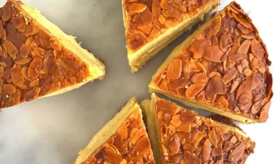 Tranches d'un délicieux **nid d'abeille gâteau** aux amandes grillées, disposées en cercle sur un fond marbré.