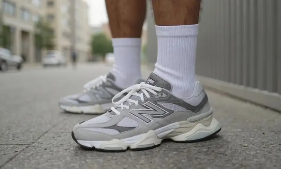 Szare buty New Balance na miejskim chodniku. Stylowy poradnik, jak nosić klasykę.
