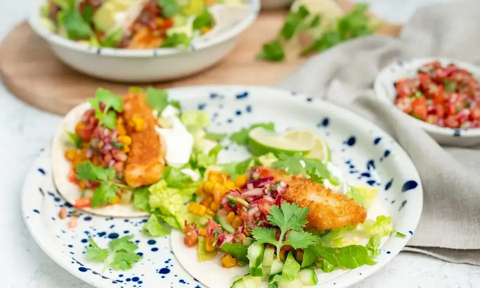 Två läckra fish tacos med krispig fisk, färsk salsa, majs och grönsaker. En festlig måltid!
