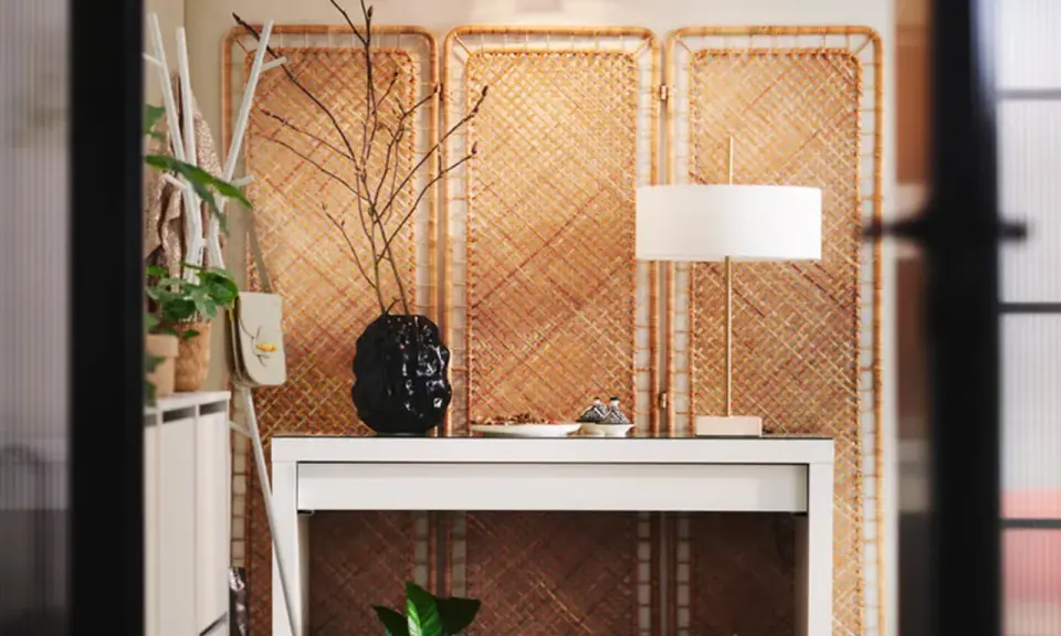 Skapa en mysig atmosfär och designa ditt rum med en vit hylla, en svart vas med grenar och en stilren lampa.