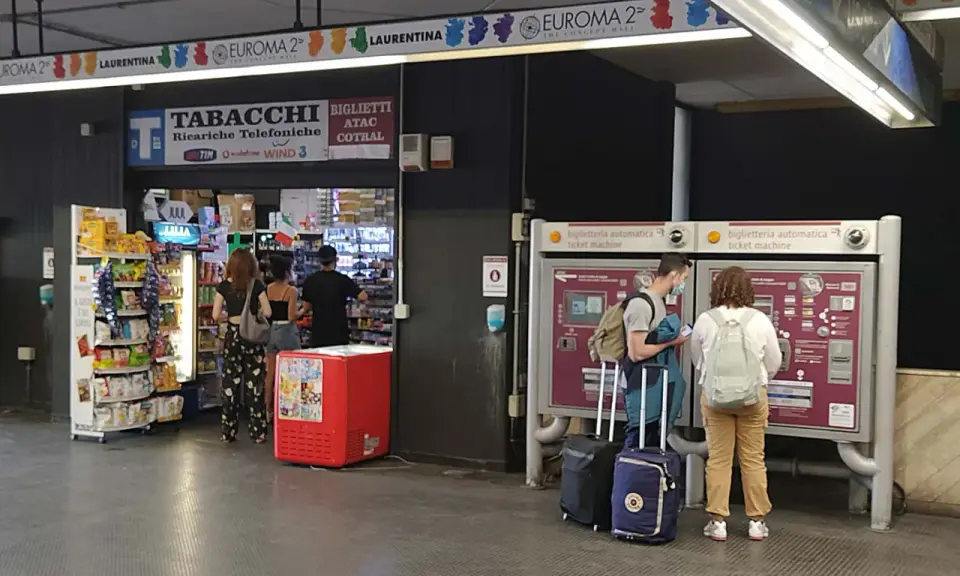 Przystanek autobusowy w Rzymie Ciampino. Ludzie kupują bilety i artykuły w sklepie.