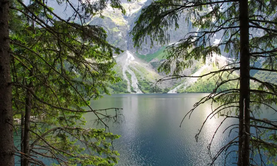 Morskie Oko, Tatry. Spokojna tafla jeziora odbija skaliste szczyty gór.
