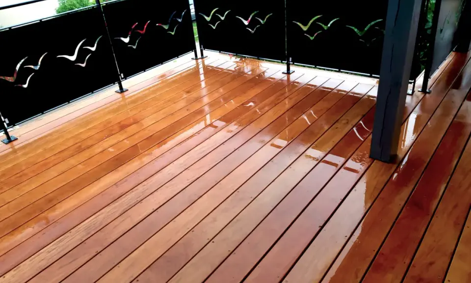 Terrasse privative en copropriété avec un plancher en bois brillant et des panneaux décorés de silhouettes d'oiseaux.