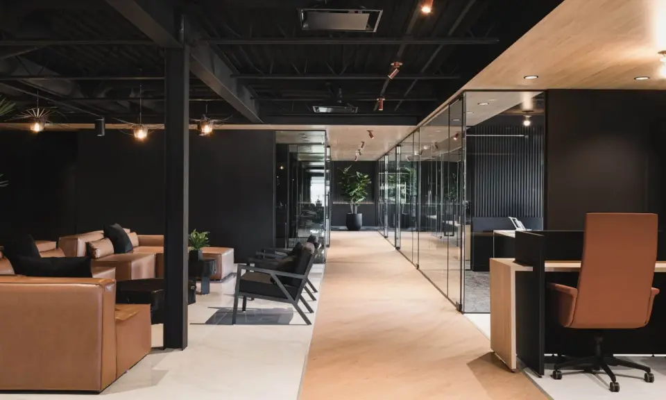 Un espace de travail innovant avec des canapés en cuir, des chaises modernes et des bureaux vitrés.