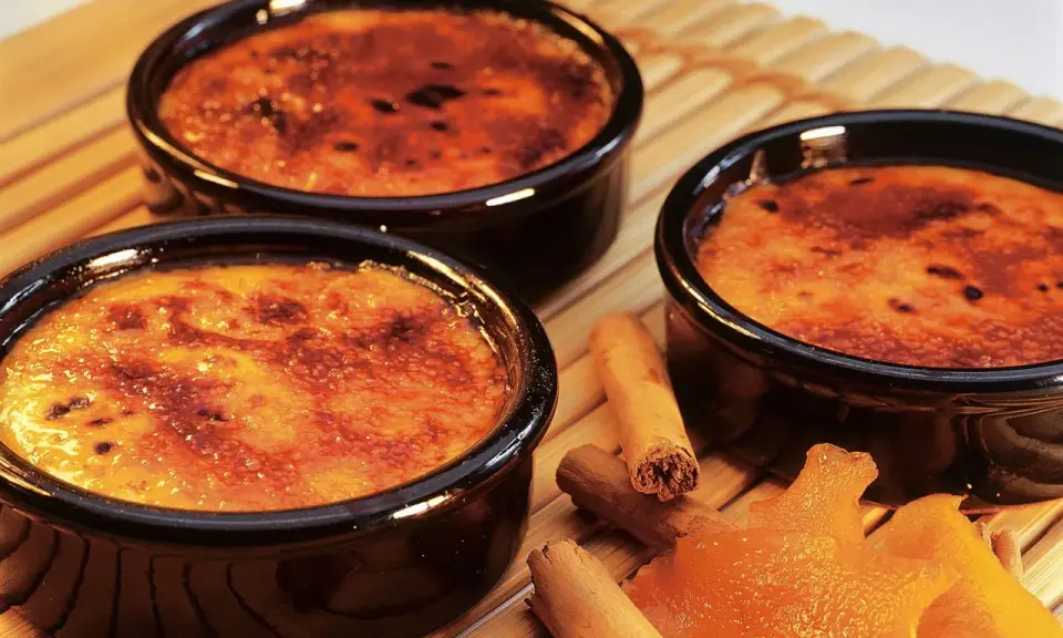 Trois crèmes brûlées aux notes d'agrume et de cannelle, évoquant la crème catalane origine.