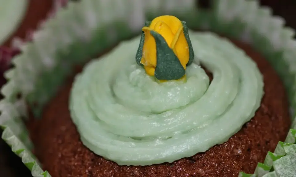 Chokladmuffins med ljusgrön frosting och en gul ros. Ett enkelt frosting recept för dekoration.