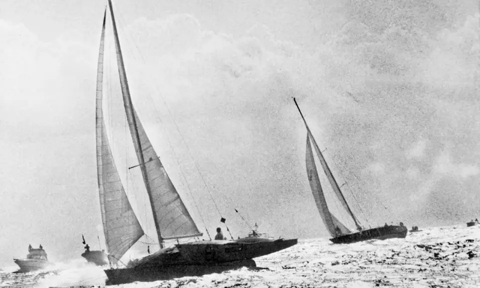 Course de voiliers en pleine mer, avec Michel Malinovsky à la barre d'un des bateaux.