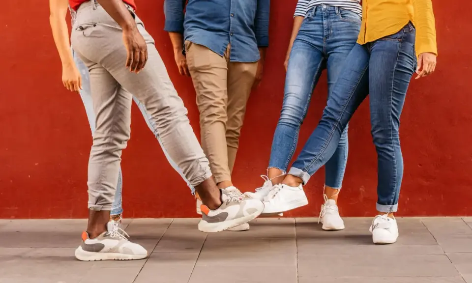 Vier Personen mit stylischen Sneakern stoßen ihre Füße aneinander. Perfekt für einen Sneaker-Blog!