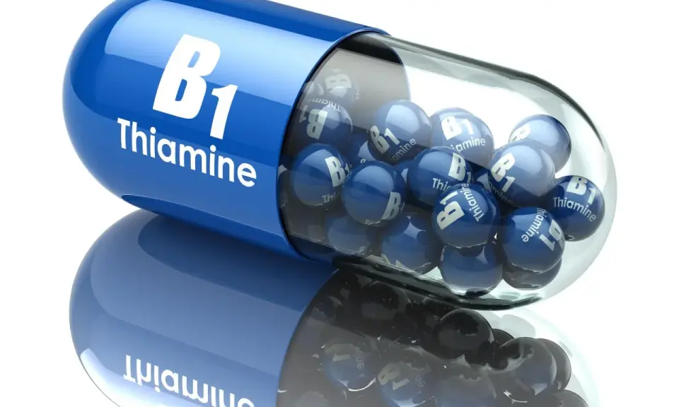 Duża, niebieska kapsułka z napisem "B1 Thiamine" wypełniona mniejszymi, niebieskimi kulkami z tym samym napisem. To jakby wizualizacja działania benfogamma forte.