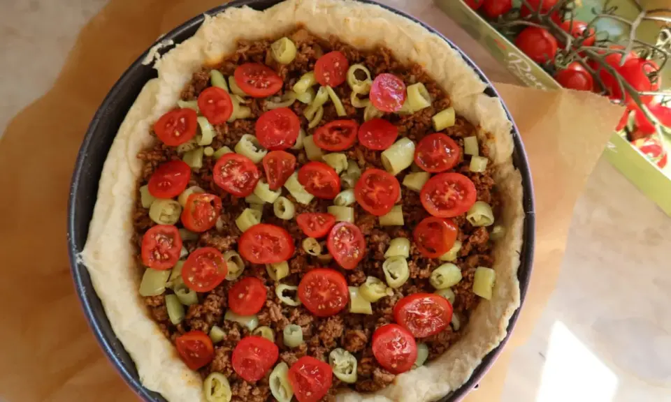 En tacopaj redo att bakas, fylld med köttfärs, tomater och paprika. Ett perfekt tacopaj recept för helgen!