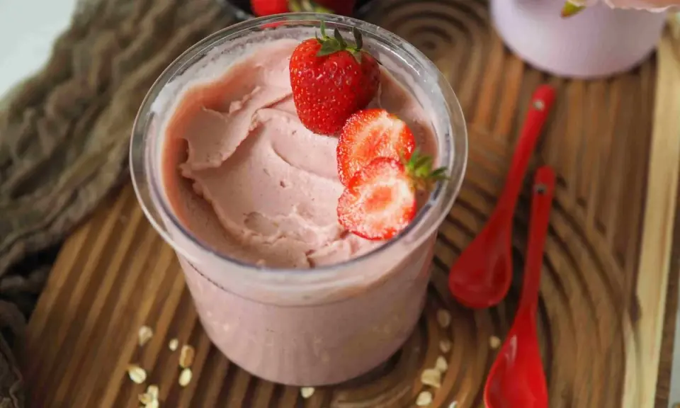 Cremiges Kefir Eis mit frischen Erdbeeren garniert, bereit zum Genießen.