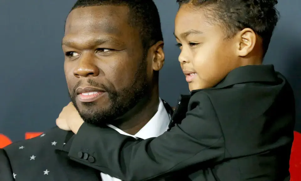 50 Cent z synem, chłopiec w czarnym garniturze przytula się do ojca.