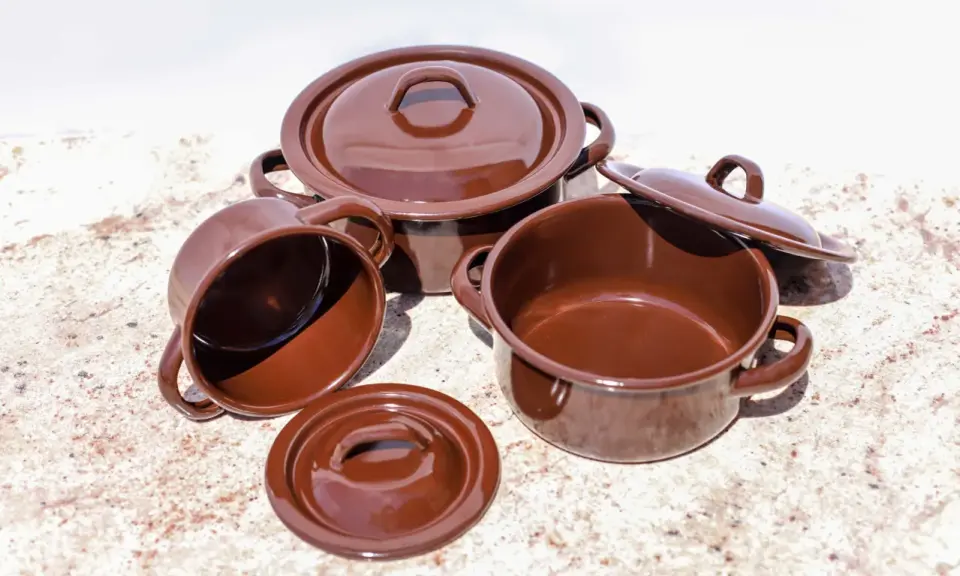 Conjunto de cazuelas de barro esmaltada en marrón. Listas para curar y preparar deliciosos guisos.