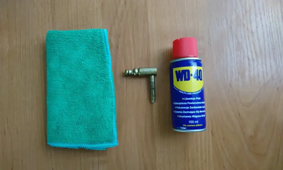 Ściereczka, mosiężny element i puszka WD-40 – wszystko gotowe do czyszczenia mosiądzu.
