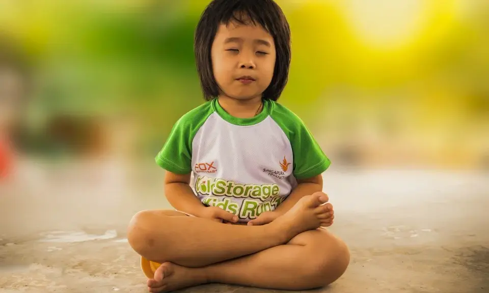 Niño meditando, una de las actividades del método Montessori para fomentar la calma y la concentración.