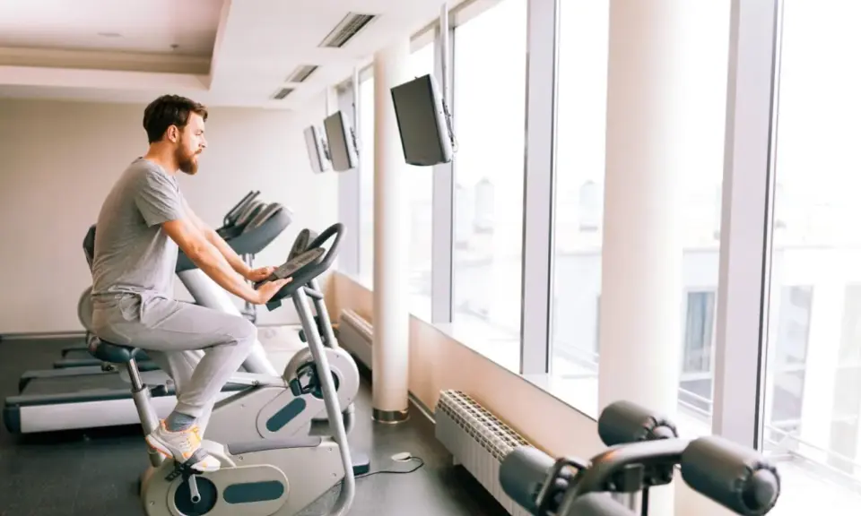 Mężczyzna ćwiczy na rowerze stacjonarnym, który może być dobrym wyborem, jeśli zastanawiasz się, jaki rower stacjonarny do rehabilitacji kolana wybrać.