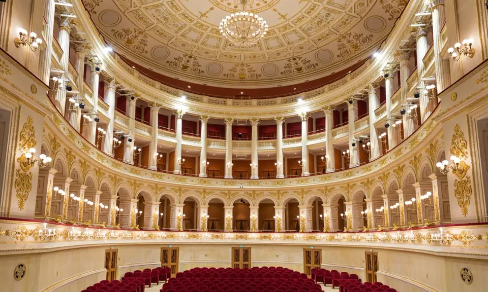 Interni sfarzosi del teatro Amintore Galli, con poltrone rosse e decorazioni dorate. Scopri i prossimi eventi!