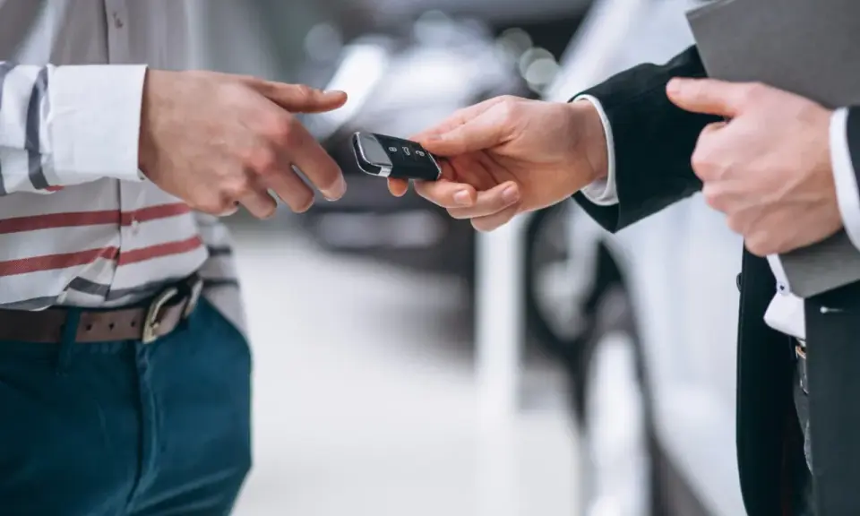 Un hombre entrega las llaves de un coche para una tasación de vehículo.