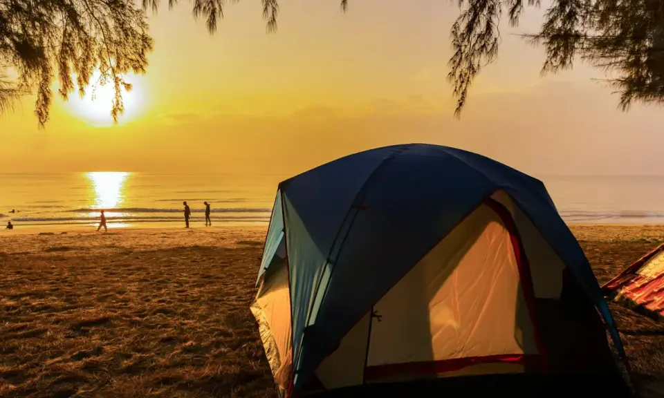 Namiot na plaży o zachodzie słońca. Idealne miejsce na najlepsze pola namiotowe nad morzem.