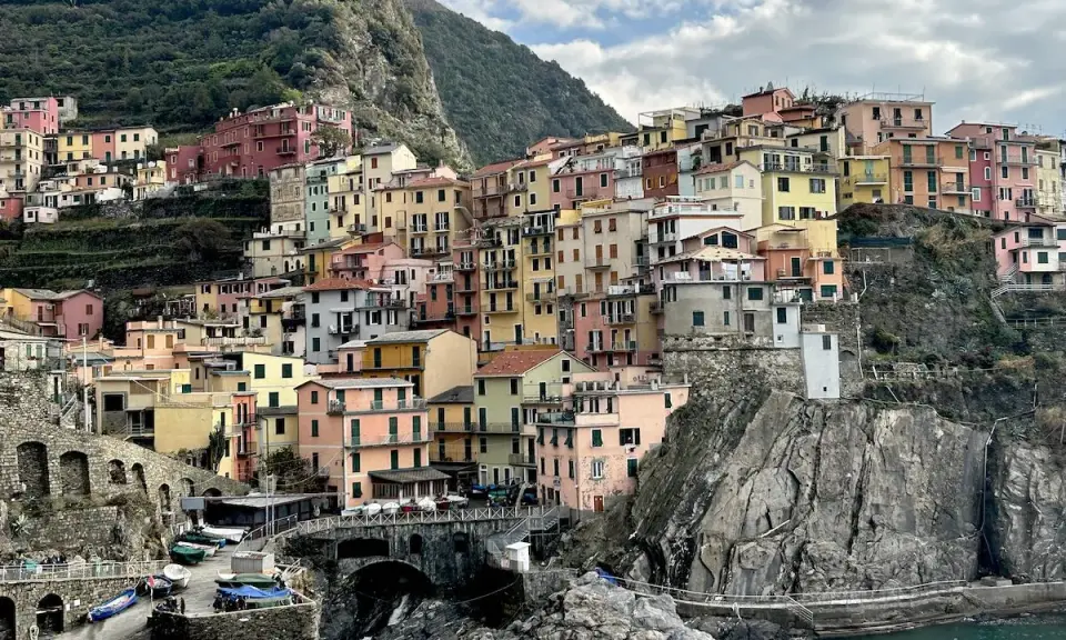 Case colorate aggrappate alla roccia, un paesaggio da cartolina. Cinque blues per la banda Monterossi, un'armonia di tinte vivaci che abbraccia il mare.
