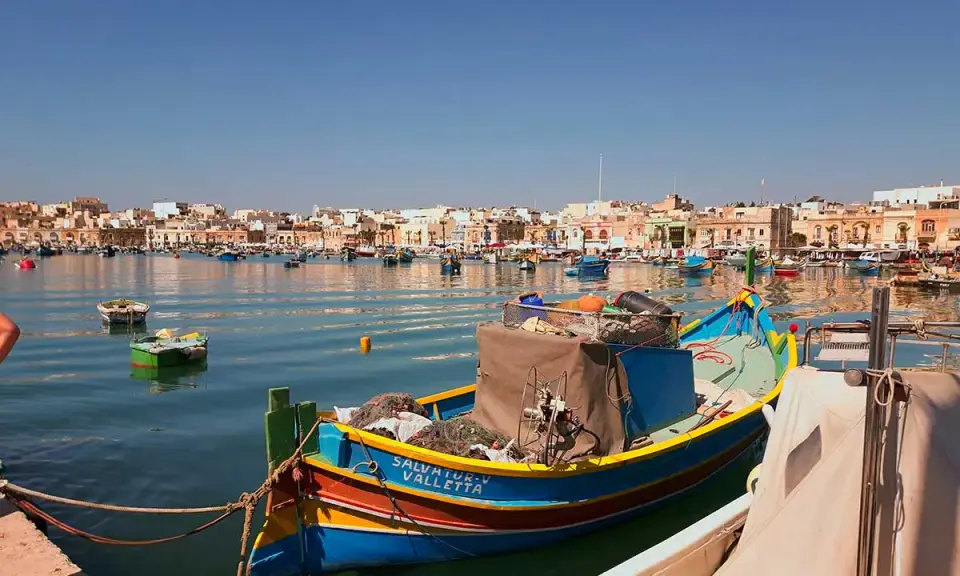 Färggranna fiskebåtar i hamnen, en dröm om att flytta till Malta.