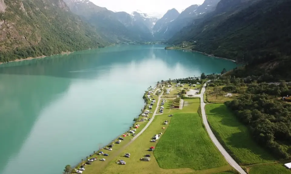Vacker vy över en sjö med berg och campingplatser i Norge. Perfekt för dig som söker campingplatser Norge.